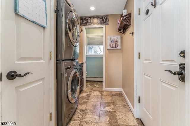 laundry room featuring baseboard heating and stacked washing maching and dryer