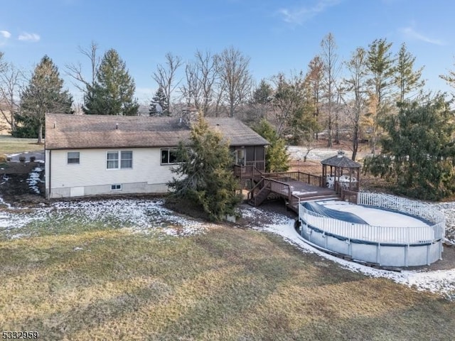 back of house with a gazebo, a swimming pool side deck, and a yard