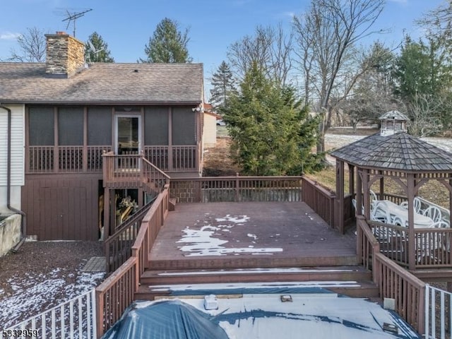 snow covered deck featuring a sunroom