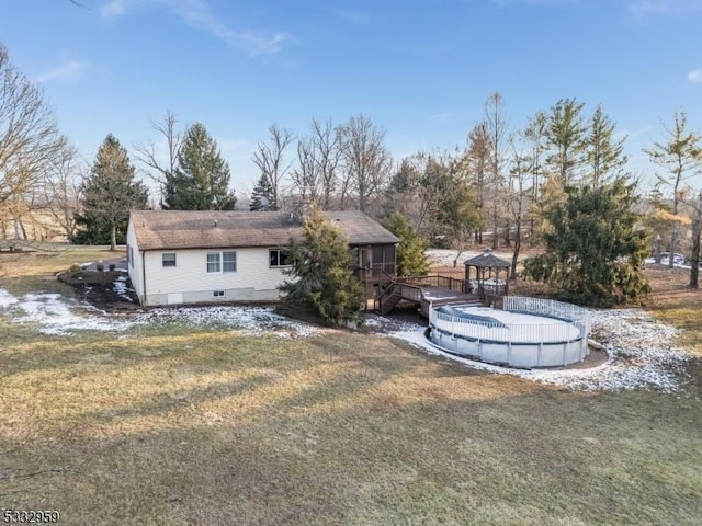 back of house featuring a swimming pool side deck and a lawn