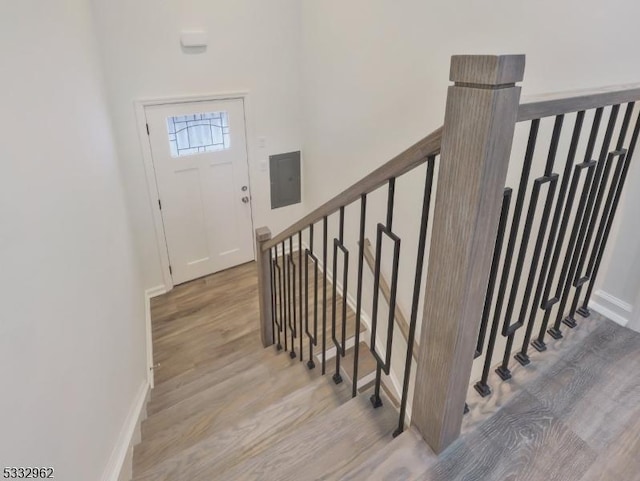 stairway featuring electric panel and hardwood / wood-style floors