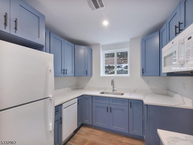 kitchen featuring white appliances, light wood-type flooring, blue cabinets, and sink