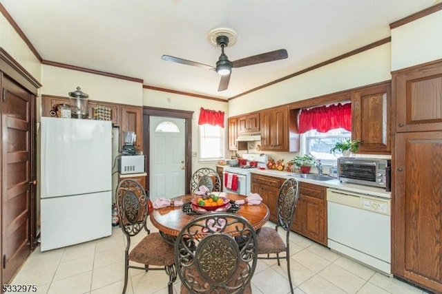 kitchen with ornamental molding, plenty of natural light, light tile patterned floors, and white appliances