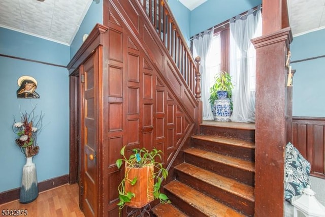 stairway featuring crown molding and hardwood / wood-style flooring