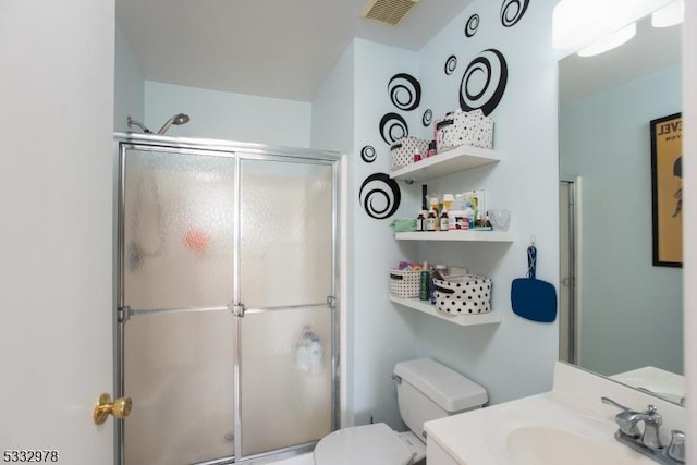 bathroom with an enclosed shower, vanity, and toilet