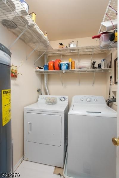 laundry room featuring water heater and independent washer and dryer