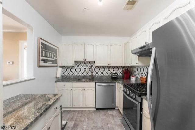 kitchen featuring white cabinets, appliances with stainless steel finishes, sink, and light hardwood / wood-style flooring