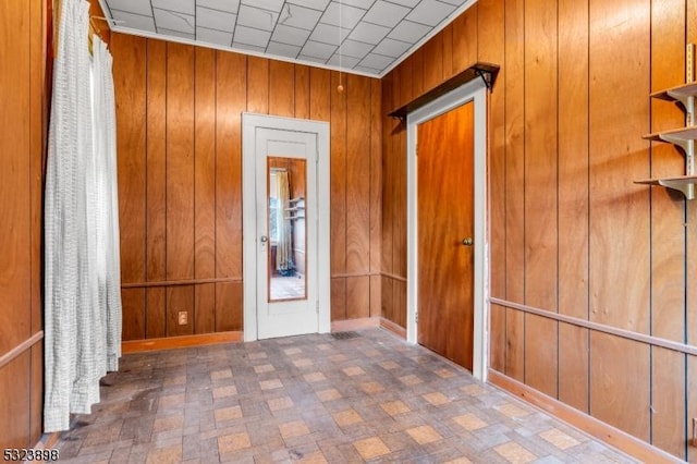 hallway featuring wood walls