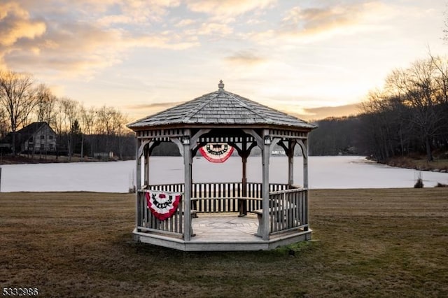 dock area with a gazebo, a lawn, and a water view