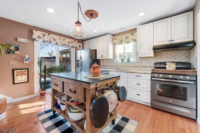 kitchen with white cabinetry, decorative backsplash, sink, pendant lighting, and stainless steel appliances