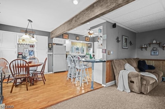 kitchen with white cabinetry, white refrigerator, hanging light fixtures, ceiling fan, and beam ceiling