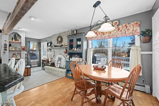 dining area featuring beam ceiling, hardwood / wood-style flooring, and a baseboard radiator