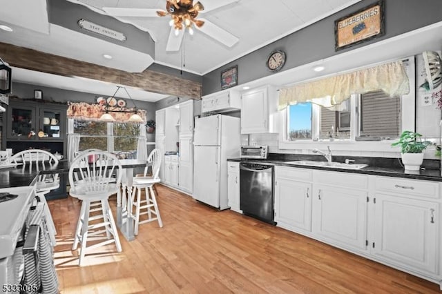 kitchen featuring ceiling fan, dishwasher, white refrigerator, white cabinets, and sink