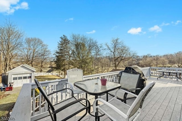 wooden deck with a garage and an outbuilding