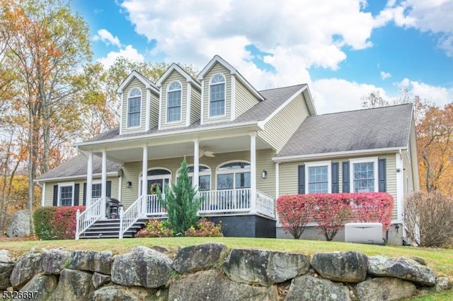 new england style home featuring a porch and a front yard