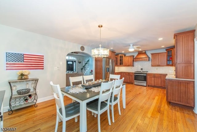 dining room featuring ceiling fan with notable chandelier and light wood-type flooring