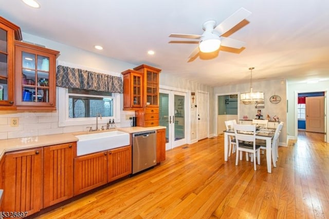 kitchen with decorative light fixtures, sink, backsplash, ceiling fan, and stainless steel dishwasher