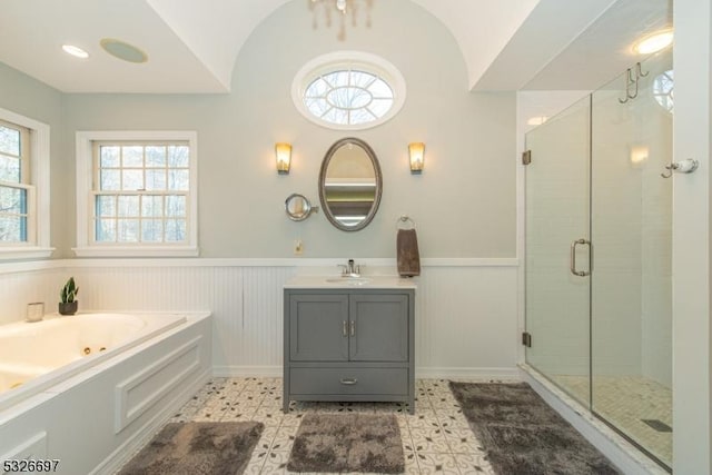 bathroom featuring vanity, independent shower and bath, and vaulted ceiling