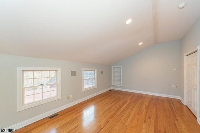 interior space with light wood-type flooring and vaulted ceiling