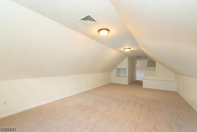 bonus room featuring light colored carpet and lofted ceiling