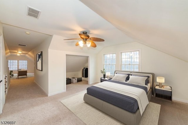 carpeted bedroom featuring ceiling fan, multiple windows, and lofted ceiling