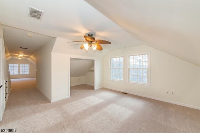 bonus room with light carpet, ceiling fan, vaulted ceiling, and plenty of natural light