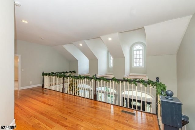 additional living space featuring vaulted ceiling and hardwood / wood-style floors