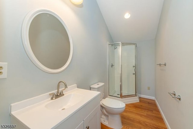 bathroom with walk in shower, vanity, vaulted ceiling, and toilet