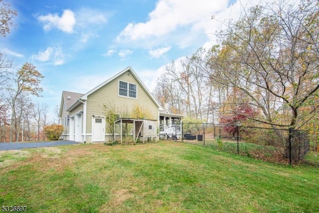 rear view of property featuring a lawn and a garage