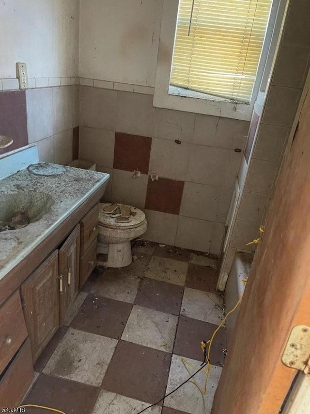 bathroom with toilet, a bathtub, and vanity