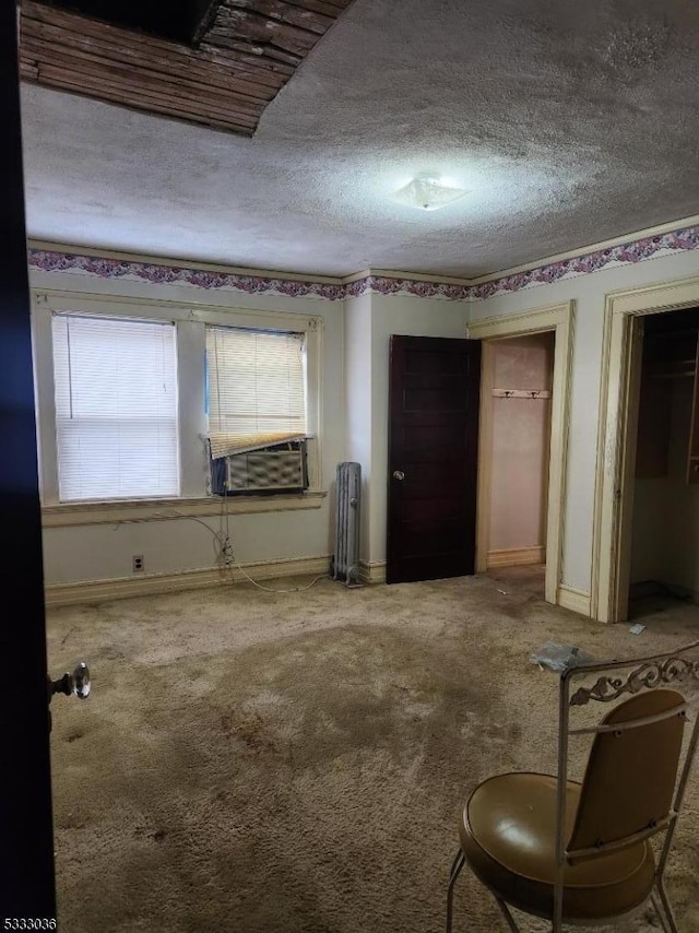 interior space featuring cooling unit, radiator, and a textured ceiling