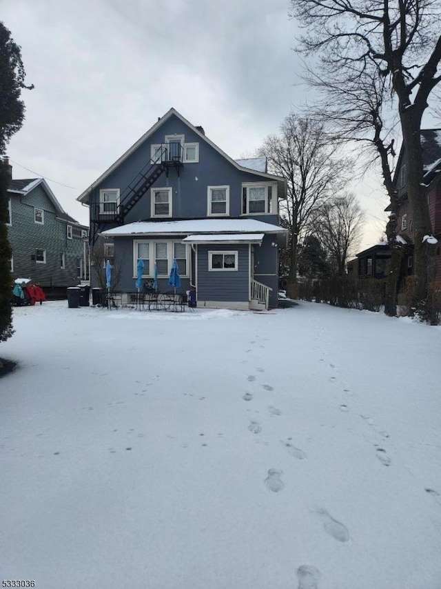 view of snow covered rear of property