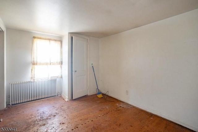 unfurnished room featuring radiator heating unit