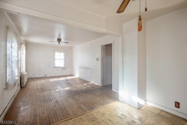 empty room with hardwood / wood-style floors, radiator heating unit, and ceiling fan