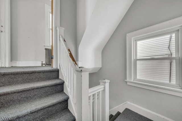 stairs with radiator and lofted ceiling