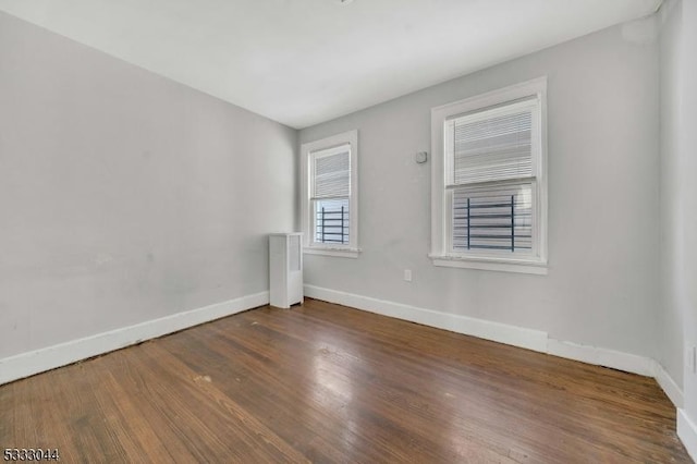 unfurnished room with dark wood-type flooring