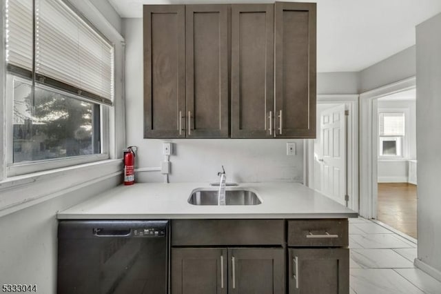 kitchen with dark brown cabinets, dishwasher, and sink