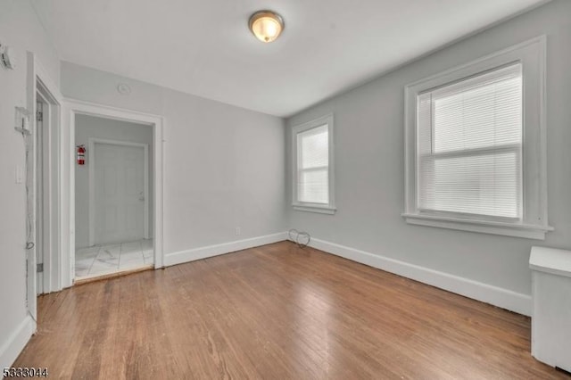 empty room featuring plenty of natural light and light hardwood / wood-style flooring