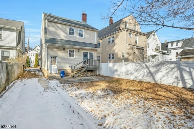 view of snow covered back of property