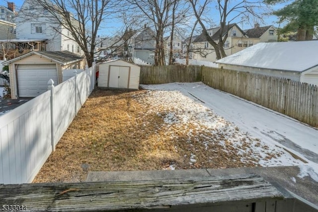 snowy yard featuring a shed