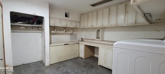 clothes washing area with cabinets and washer / dryer