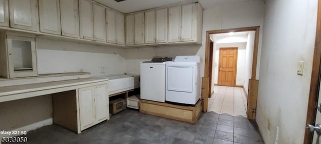 clothes washing area with washer and clothes dryer and cabinets