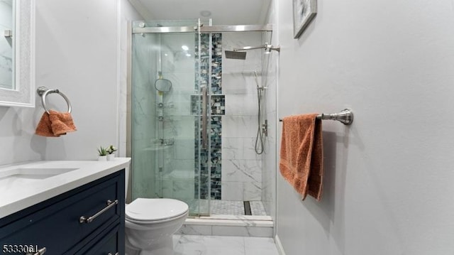 bathroom with an enclosed shower, vanity, and toilet