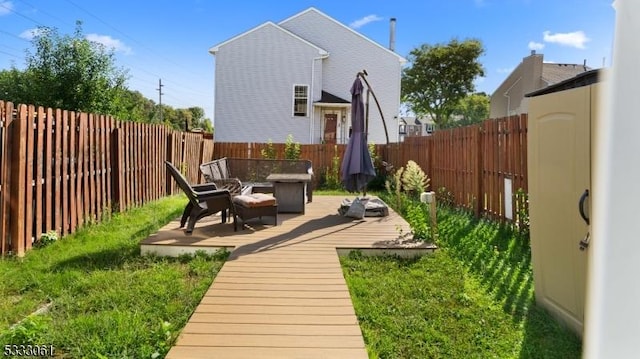 rear view of property with a deck and a fire pit