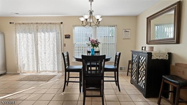 tiled dining room featuring an inviting chandelier