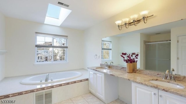 bathroom featuring shower with separate bathtub, a skylight, tile patterned flooring, and vanity