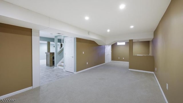 basement featuring light carpet