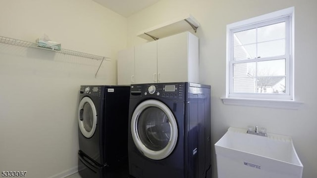 washroom featuring cabinets, sink, and washing machine and clothes dryer