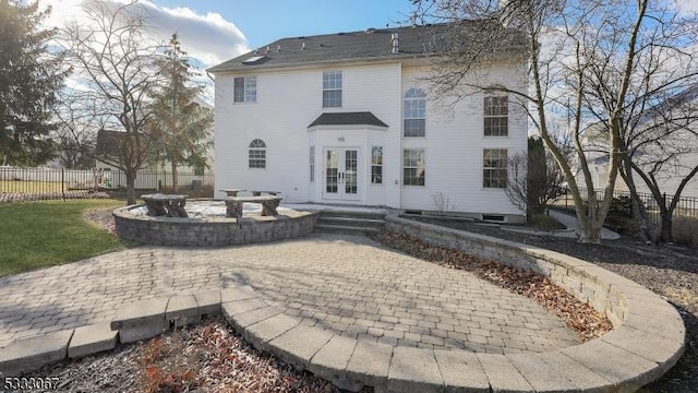 rear view of house featuring french doors, a patio, and a fire pit