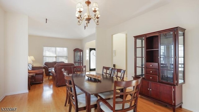 dining space featuring light hardwood / wood-style flooring and a chandelier